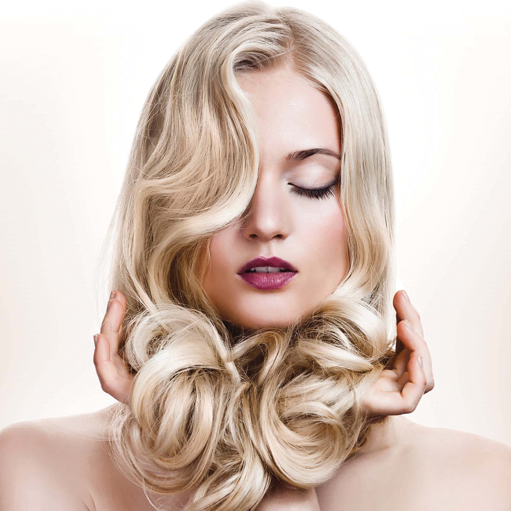 Frau mit glänzendem blondem Haar und voluminösen Locken